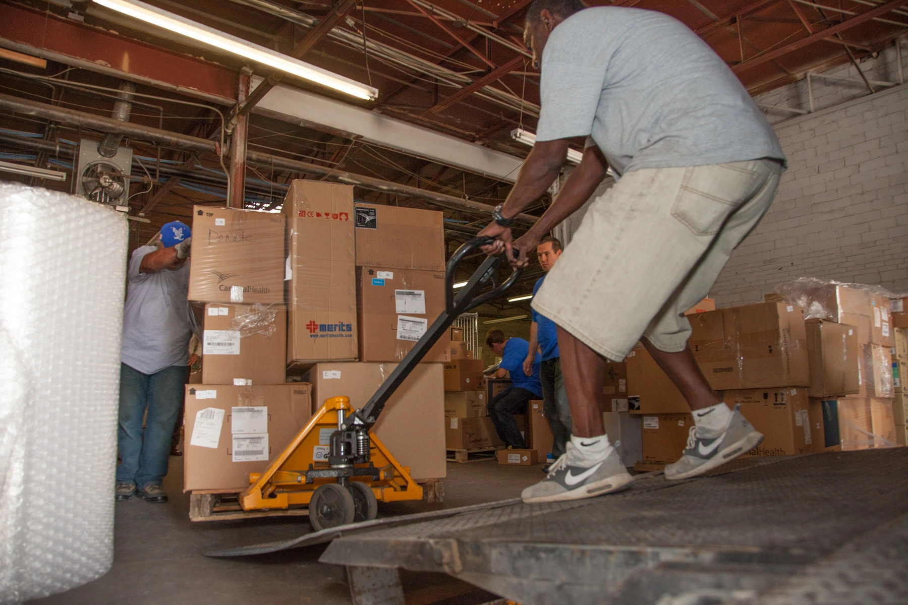 Faith In Action Initiatives volunteers help prepare cargo for shipment