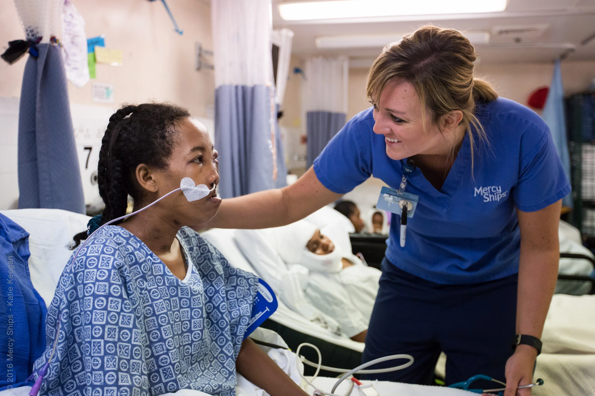 ©2016 Mercy Ships - Crédito de la foto Katie Keegan - La enfermera de la sala Nikki VERMEER (EE. UU.) cuida a Olivienne (MGC05050) en la sala maxilofacial.