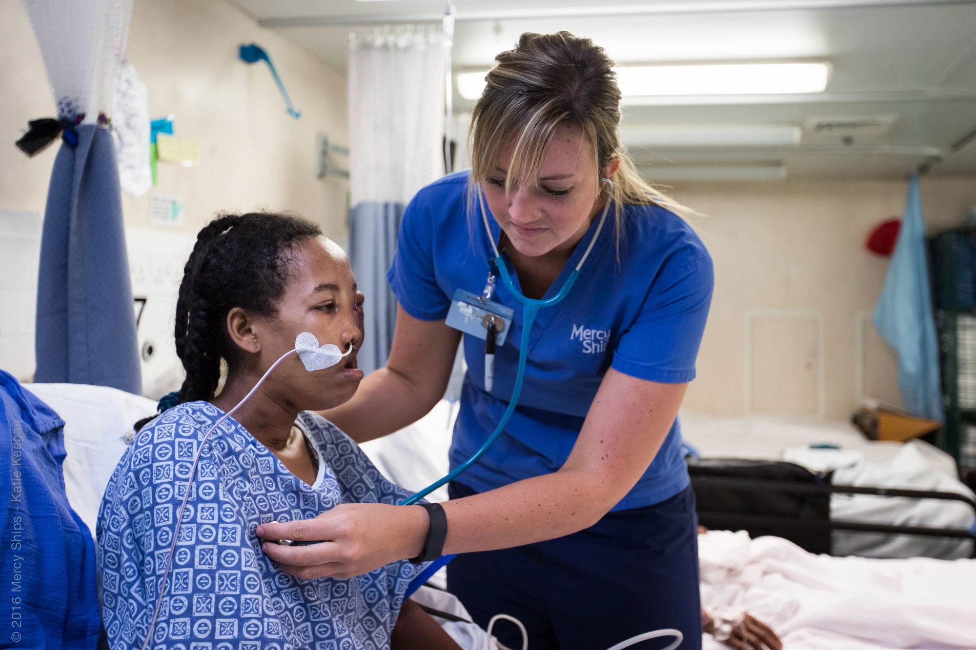 ©2016 Mercy Ships - Photo Credit Katie Keegan - Ward Nurse Nikki VERMEER (USA) cares for Olivienne (MGC05050) in the maxillofacial ward.